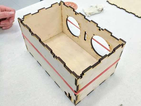 (6)Wrap a large red rubber band around your box.  This will apply pressure to all four sides and hold them together while the glue sets up.