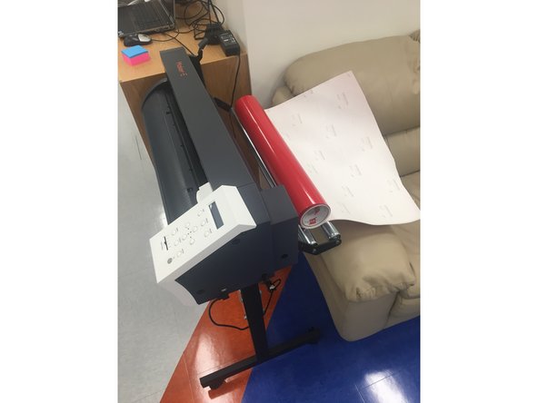 If you are using a roll a vinyl, set the roll on the silver rollers located on the back of the vinyl cutter so that the colored vinyl side of the roll is facing up when vinyl is pulled from the roll.
