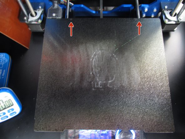 Once the print surface is clean, please replace it on the metallic print bed.   Orient the surface so that the two holes in the surface are located towards the back of the printer and the cutout is located towards the front.