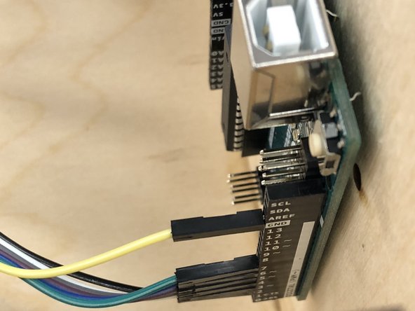 The ribbon cable will attach to the terminals on the right-hand side (as you face the box) of the Arduino.