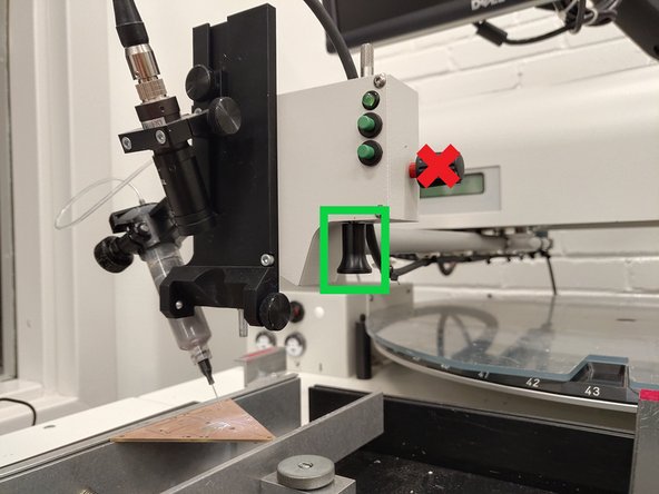 Hold the black placement knob on the lower right side of the placement head and slowly move the placement head so that the tube is over the top of your PCB.  Make sure that there is clearance between the end of the solder paste nozzle and the PCB.  You want about a half inch vertical gap between the end of the nozzle and the PCB.