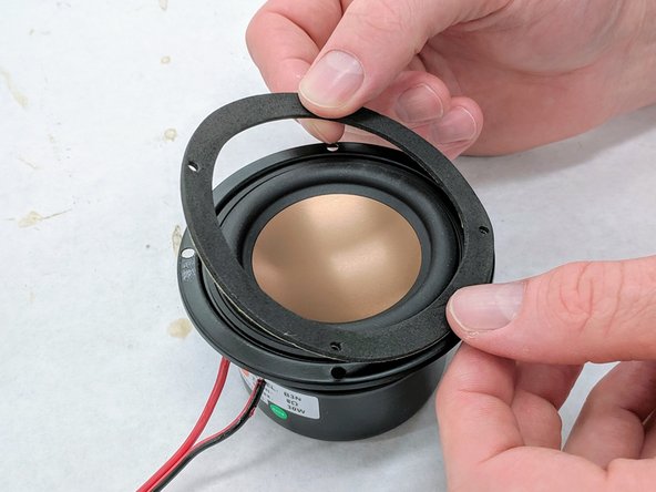 Remove the paper covering from the back of the gasket and adhere the gasket to the front of the speaker.  Do not place the gasket on the back of the speaker.