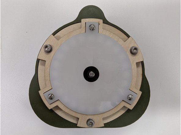 Gently insert the PCB assembly into the shell back, keeping the ESP32 module pointing towards the top of the shell back where the two large holes are.  The stepper motor wires should be pointing down towards the flat bottom of the shall back.  See the first image.