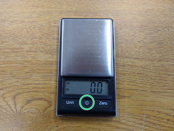 Locate the digital scale.  Remove the plastic cover, press the power button, and wait for the scale to calibrate and display 0.0 g.