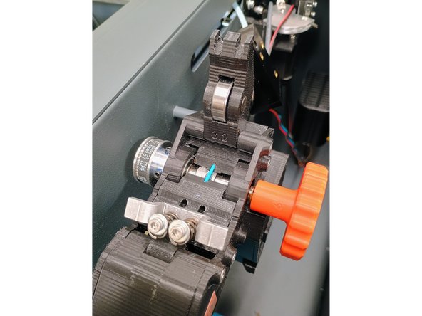 Feed the filament through the entrance hole and through the next hole now visible, as seen in the second image.
