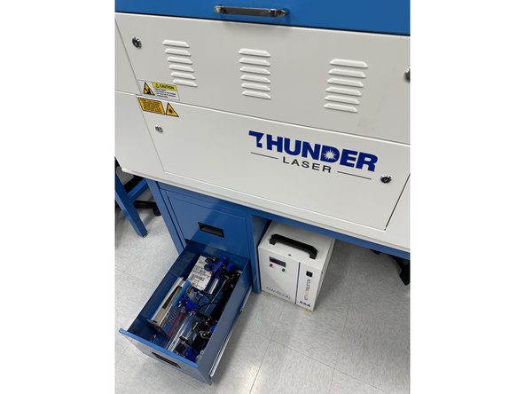 Underneath the Thunder Laser the last drawer contains the RotoBoss rotary chuck attachment. Take it out and set it on a table.