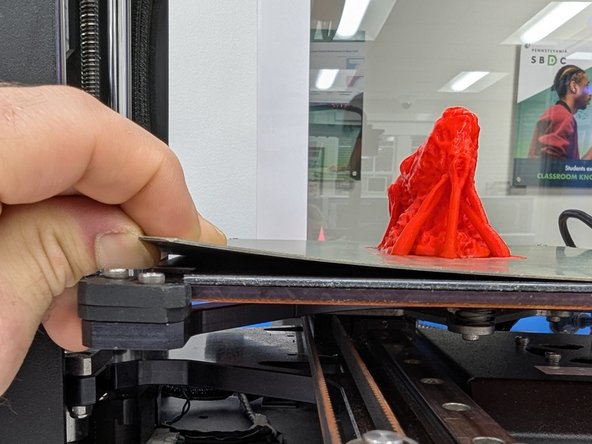 When your print is complete the printer will move the bed down and move the print head out of the way.  You should carefully lift a corner of the metallic print surface to completely detach it from the magnetic bed.