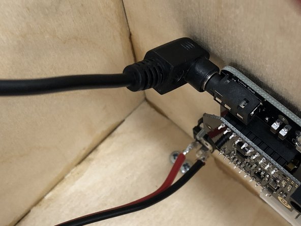 The audio wire plugs into the audio jack in the upper-left corner of the amplifier.
