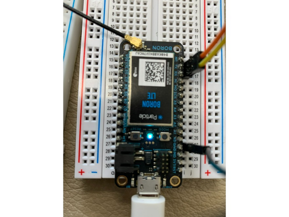 Connect a jumper cable from GND on the particle board to the Feather M4. Then, connect RX on the particle board to TX on the Trinket M0 and TX on the particle board to RX on the Trinket M0.