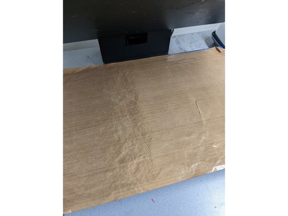 Once your design is aligned, place the brown sheet on top of your design. Then pull the lever at the top of the heat press down and push it until it locks in place.