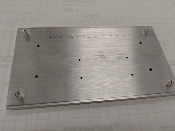 Screw in the M3 standoffs into the outermost four corner holes of the baseplate. These will be used to hold the PCB in place.