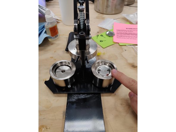 Read carefully: with both die perpendicular to the press, make sure that the pinback is co-linear to the rotating base.