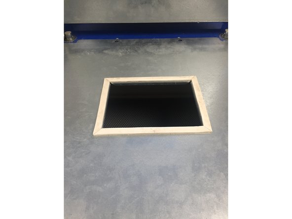 Place the frame that has the soft edging around its square upright and on the top of the table. The two holes located at the top of this frame should line up with the two holes on the machine.