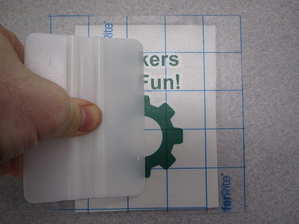 You should use the white plastic squeegee to firmly apply the tape to your sticker and ensure there are no air bubbles between the tape and sticker.