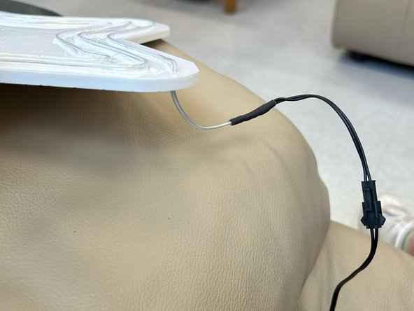 Thread the black end of the wire through the hole to the back of the sign.