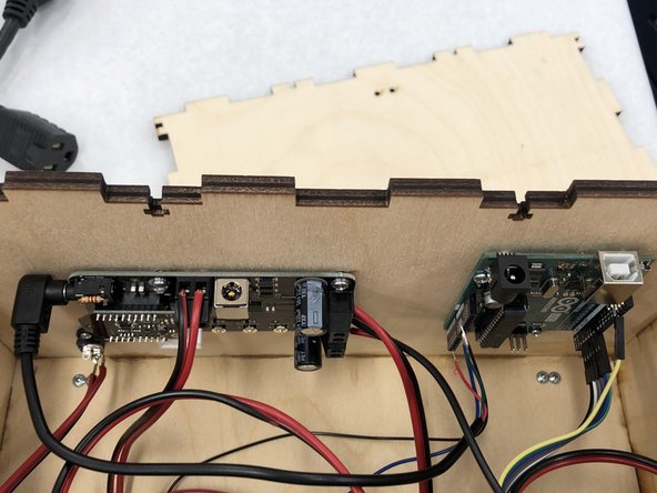 Connect the remaining black and red cord to the screw terminals at the top of the amp.  The black wire goes into the left side (as you are facing the box), the red wire into the right (as you are facing the box).  Tighten the screw terminals to hold the wires in place.
