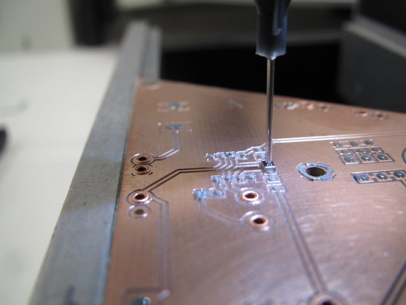 Viewing the PCB directly, or watching the microscope display, align the component over the appropriate pads on the PCB.  Rotating the black placement knob will rotate the component.