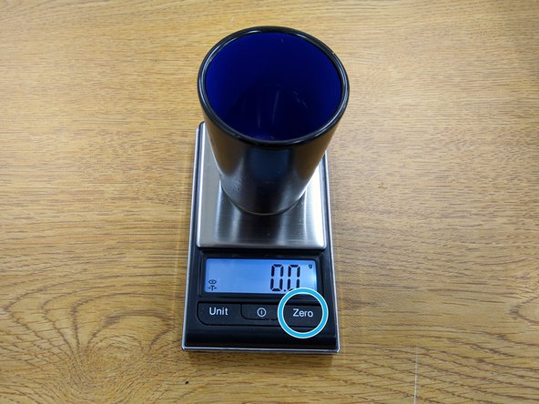 Place an empty espresso glass on the scale.  Wait for the scale to measure the weight of the glass and then press the Zero button.