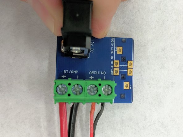 Find the remaining 12&quot; length of 18 gauge wire.  Insert one of the red ends into the far left terminal block labelled &quot;+ BT/AMP&quot;.  Insert the black lead into the &quot;-- BT/AMP&quot; slot.  Tighten the screws of these terminal blocks to hold the wires in place.