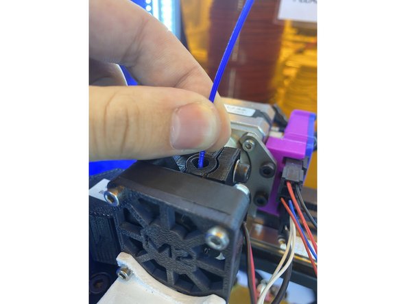 Before inserting the new spool of filament, make sure to clip the end of the filament with a pair of wire cutters. The cut should be at about a 45 degree angle so that the filament tapers diagonally to a sharp point. This makes it easier to insert into the extruder head.