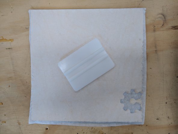 It is helpful to hold the tape down with your left hand while your right hand unrolls the tape.  With the tape firmly held in place, unroll enough tape to cover your entire piece of material.