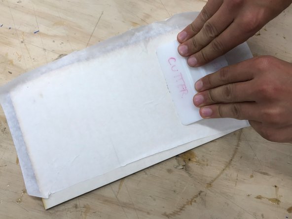 You must use the squeegee (found near the protective layer roll) to make sure there are no air cavities between the protective layer and the material sheet.  Failure to use the squeegee could allow the paper to peel during cutting which could ignite and cause a fire.