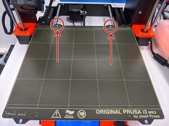 The final step is to place the print surface back on the printer.  Use the two locating pins at the rear of the print bed to properly align the print surface.
