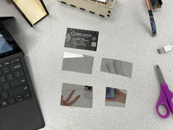 Grab the mirror sticker and some scissors. Cut 4 rectangular pieces that will roughly fit the inside of the box. The fit doesn't have to be perfect, it just has to cover most of the box.