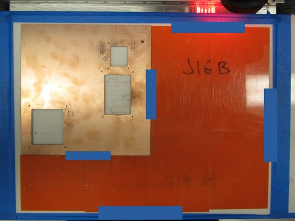 Add some blue tape to adhere the copper clad to the jig, and to adhere the jig to the mill bed.  Keep the tape away from where the mill will be fabricating your PCB, as having tape in the way can interfere with proper milling.