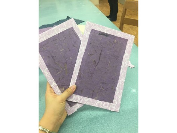 Lightly coat the end papers with glue and stick them over the cardboard cutouts.