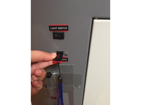 Take the flashdrive that you saved your laser cut file to and insert it on the right side of the laser cutter close to the bottom of the machine.