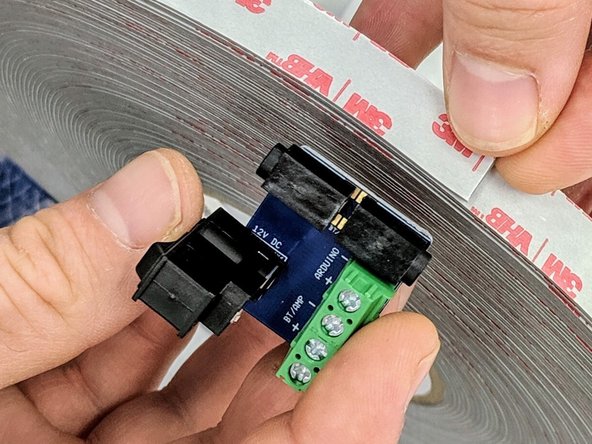 (9)The wood glue should now be sufficiently dry to continue work.  Remove the lid.  In your bag, locate the small blue printed circuit board (PCB) with the barrel jack/rocker switch and green terminal blocks.