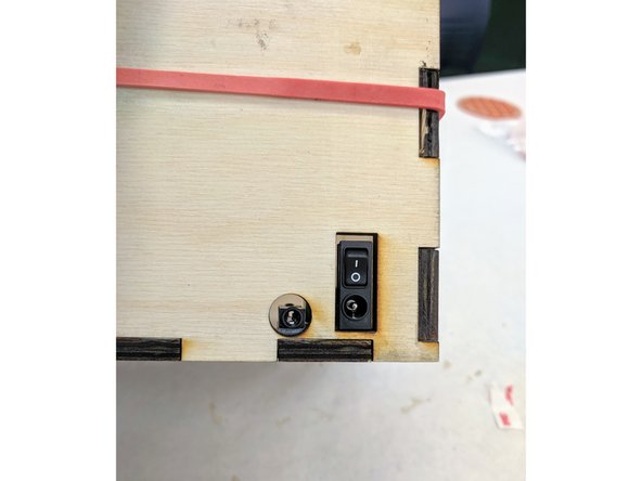 Apply firm, downward pressure to ensure that the VHB tape makes good contact with both the PCB and the wooden base.