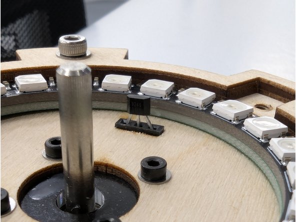 Take the Hall effect sensor with shortened leads and insert it into the corresponding slot in the front of your motor mount base.  The leads should firmly and securely insert into the 3 pin socket.  Orient the sensor so that the faint white text on the front face points in towards the motor and and away from the outer wooden ring.