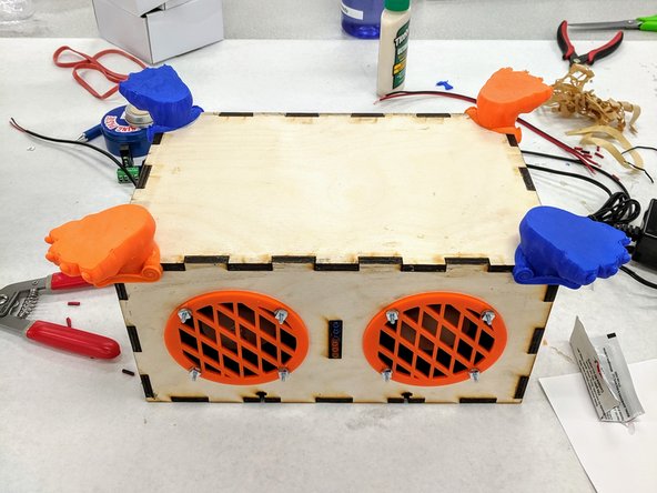 Place the foot on one of the four corners of the box.  Hold it in place for a minute to allow the epoxy time to begin to cure.