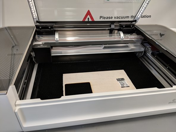 Find the material you wish to engrave/cut your design into (either below/next to the laser cutter or with you) and place it on the cutting board.  Be careful not to bump the laser head when you insert it.  You may need to open the front panel towards you.   Close the lid of the cutter.