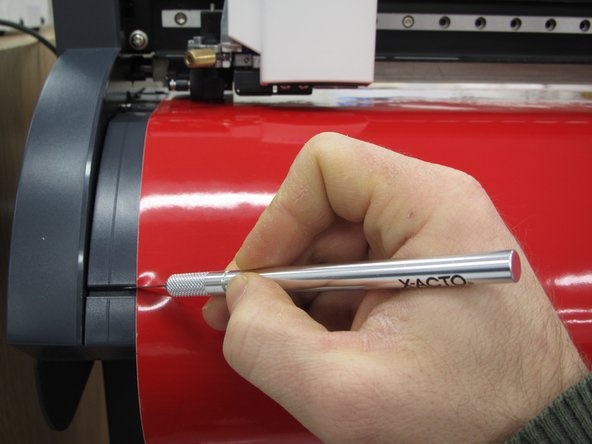 If you used a roll of vinyl, you will need to cut off the length of vinyl you used. Push the down arrow key on the vinyl cutter until your sticker is beyond the knife guide. Use an exacto or utility knife to cut along the knife guide and remove your vinyl from the machine.
