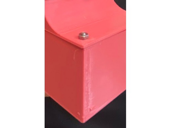 Next, take your display and insert two of your bolts into the open holes next to the jumper cables. Line up these screws with the holes in the case and make sure both go through. Hold these in place and thread on an M2 nut onto the bolt on the outer side of the case. Finger-tight is fine. Make sure that your display will stay in place.