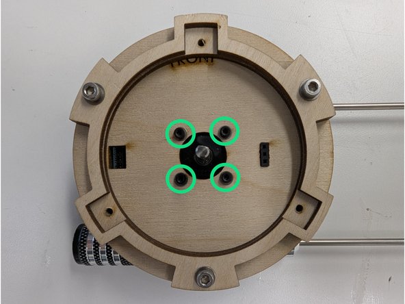 Insert the motor through the square slot in the PCB so that the shaft protrudes out of the wooden motor base.  Orient the motor so that the wires point down towards the open space on the PCB.