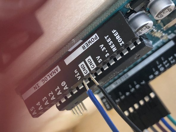 Using a blue wire and a black wire, attach  one end to the (slot) on the left-hand side (while facing the front of the box) of the Arduino.