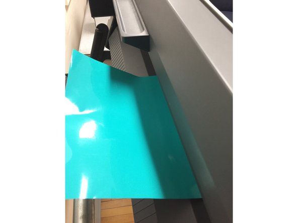 If you are working with the sticker vinyl, insert the vinyl through the vinyl cutter by sliding the vinyl through the back of the machine. Make sure the colored sticker is facing upwards.