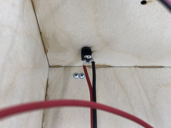 Put the barrel jack through the hole on the back of the speaker.