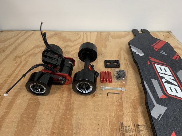 Gather the drivetrain, front truck, top rails, risers, truck hardware, wrench, 3mm Allen wrench, and deck