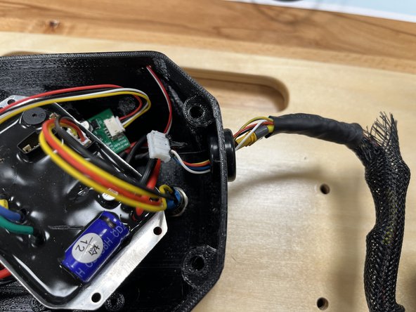 Feed the motor wires (yellow and white connector) through the hole in the enclosure.