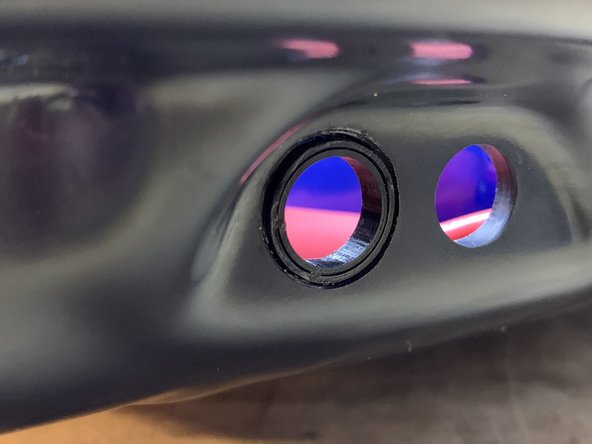 Place adhesive (superglue) on the outer rim of the spacer. Then press it into the enclosure with the rim inwards.