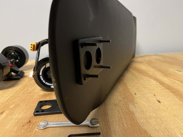 Place four of the truck bolts through the holes at the front of the deck