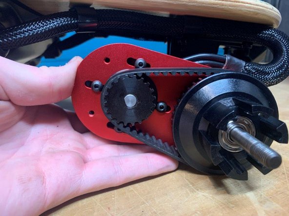 Pull back on the motor to tension the belt