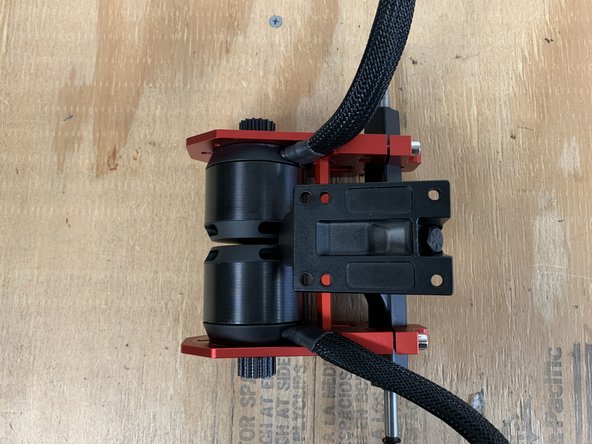 Since the cross bard is no longer included you will need to install the motor mounts in a different manner. You can align the motor mounts by eye (to the center) and then use the black 3d printed spacer to place between the wheel pulley and motor mount for final alignment.