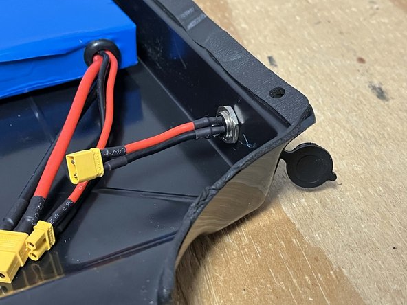 Place the charge port through the hole in the enclosure as shown and secure it with the locknut