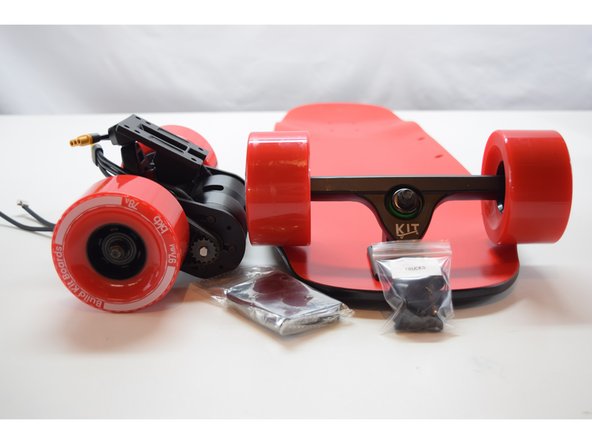 Gather the deck, front truck assembly, drivetrain assembly, 2x risers, and truck hardware.